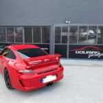 Κόκκινη Porsche 911 παρκαρισμένη έξω από το συνεργείο.