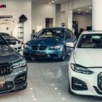 Διάφορα αυτοκίνητα BMW μέσα σε εκθεσιακό χώρο.